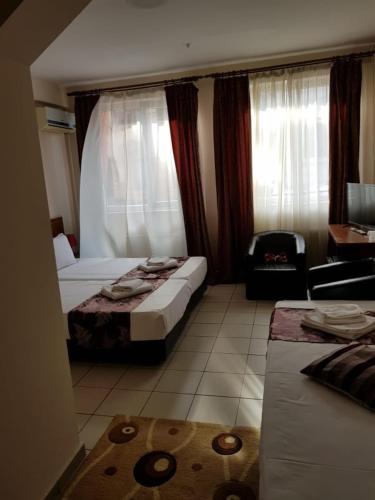 a hotel room with two beds and a chair at Hotel Tranzzit in Bucharest