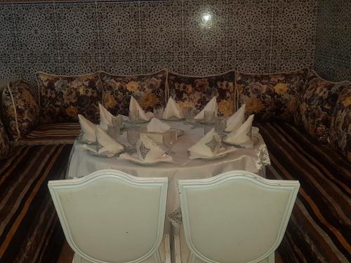 a table and chairs in a room with a couch at Dar Merzouga Meknes in Meknès