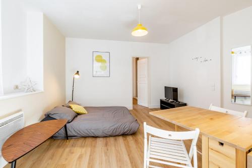 Schlafzimmer mit einem Bett und einem Holztisch in der Unterkunft Maison de ville pour 4 personnes in Marseille