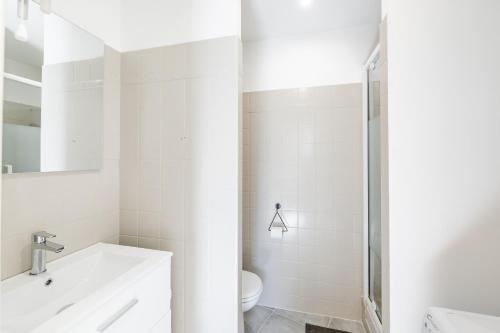 ein weißes Bad mit einem Waschbecken und einem WC in der Unterkunft Maison de ville pour 4 personnes in Marseille