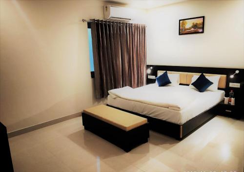 a bedroom with a bed and a stool in it at Hotel Suryansh in Udaipur