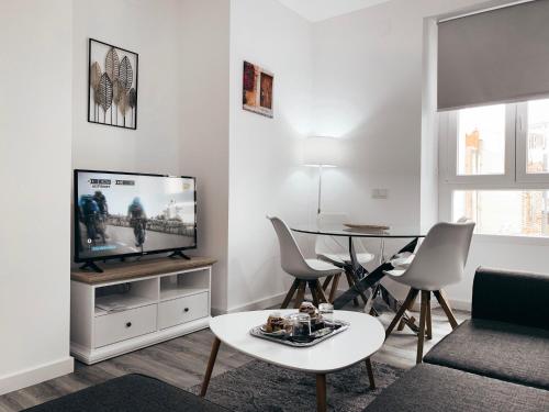 a living room with a tv and a table at Alicante Center Apart in Alicante