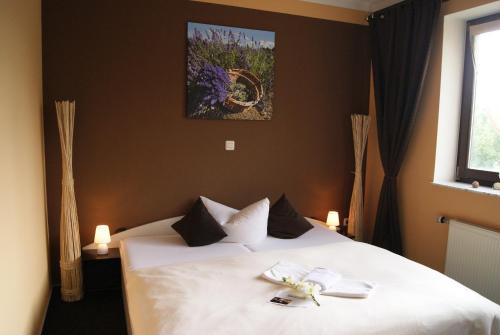 a bedroom with a bed with white sheets and a window at Landhotel Berggaststätte Bickenriede in Anrode