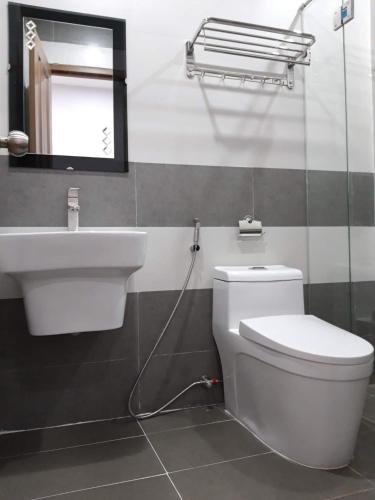 a bathroom with a white toilet and a sink at xh apartment in Danang