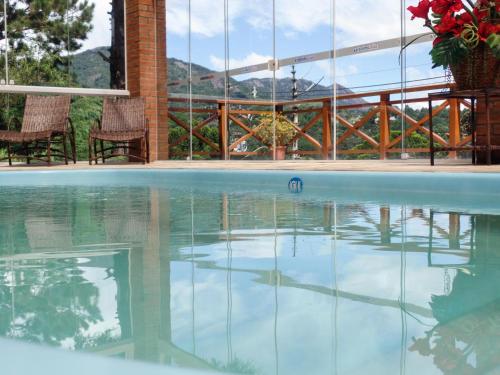 a swimming pool with a reflection in the water at Pousada Suiça Mineira Centro in Monte Verde
