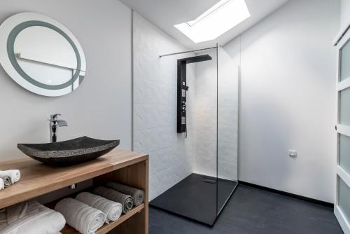 La salle de bains est pourvue d'un lavabo et d'une douche en verre. dans l'établissement Gîte de la Daudière La Grange, à Le Boupère