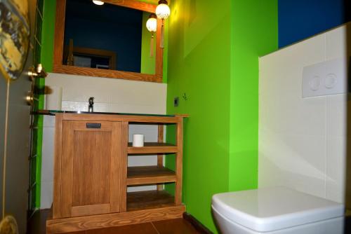 Un baño verde con inodoro y lavabo. en Alacati Suites, en Alacati
