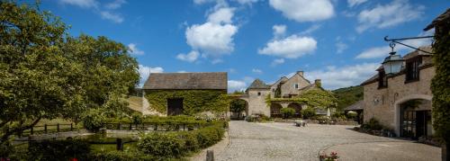 un vieux bâtiment en pierre avec une allée dans une cour dans l'établissement Le Hameau de Barboron, à Savigny-lès-Beaune