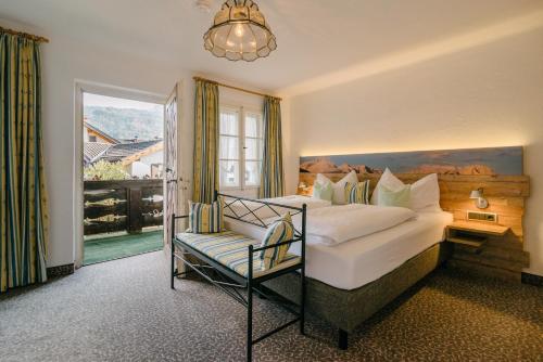 a bedroom with a bed and a chair and a window at Gästehaus Angela in Garmisch-Partenkirchen