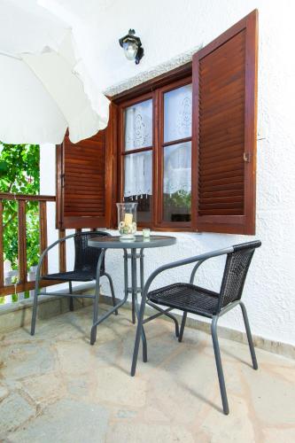 a patio with two chairs and a table on a balcony at F & B Summer Collection - Holiday Flats in Sozopoli