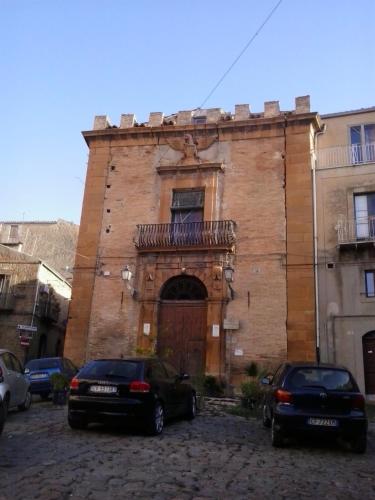 two cars parked in front of a brick building at La Dea Bendata in Piazza Armerina