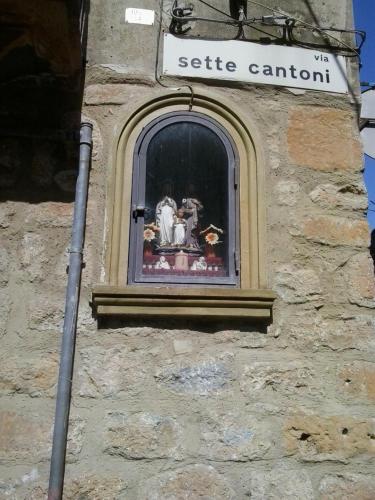 a window on a building with a statue in it at La Dea Bendata in Piazza Armerina