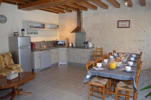 uma cozinha e sala de jantar com mesa e cadeiras em La Perronière em Athée-sur-Cher