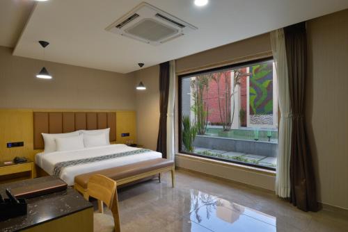 a bedroom with a bed and a large window at Treat Beach Resort in Bordi
