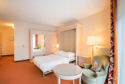 a bedroom with two beds and a table and a chair at Eden au Lac in Echternach