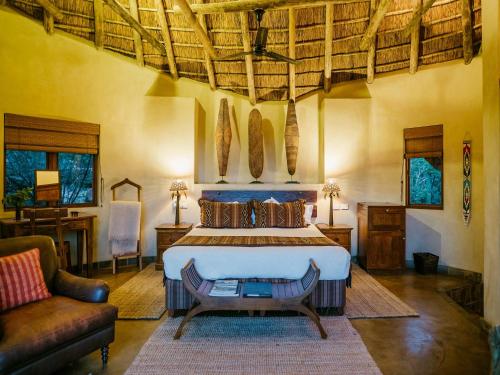 a bedroom with a large bed and a couch at Nedile Lodge in Welgevonden Game Reserve
