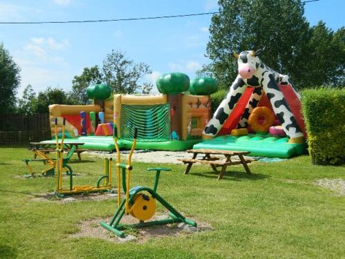 a park with a playground with a play equipment at Camping la Haie Penée **** in Saint-Quentin-en-Tourmont