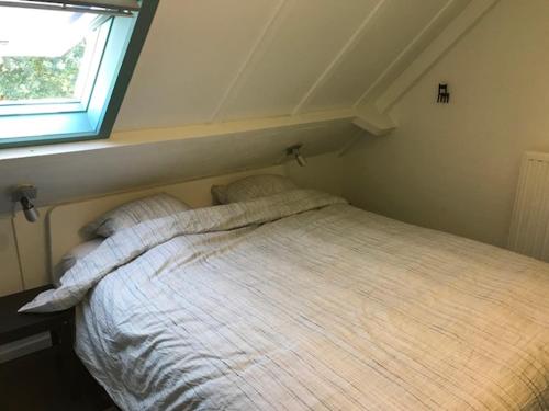 Dormitorio pequeño con cama y ventana en Ysermonde Beuger 10, en Nieuwpoort