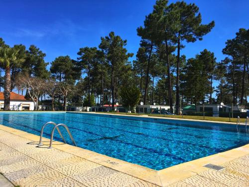 una gran piscina con árboles en el fondo en Valbom by Campigir, en Sesimbra