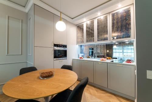 a kitchen with a wooden table and chairs in a room at Mennica Central Apartments in Warsaw