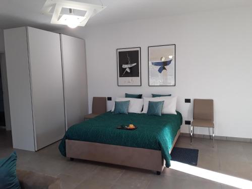 a bedroom with a bed with a green blanket at Casa Punta Veleno in Brenzone sul Garda