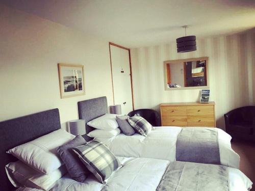 a hotel room with two beds and a dresser at Ardconnel Bed and Breakfast in Kirkwall