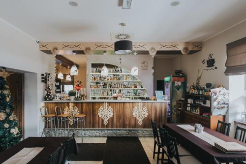 a restaurant with a bar and tables and chairs at Hotel Majerzanka in Piwniczna