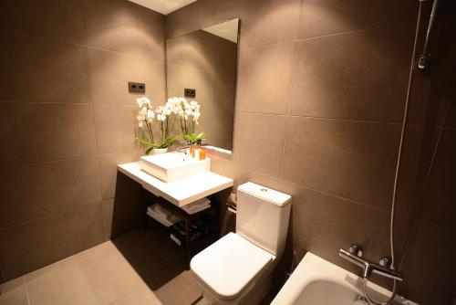 y baño con aseo blanco y lavamanos. en Apartments Hotel Sant Pau, en Barcelona