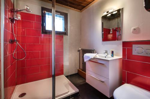 a red bathroom with a shower and a sink at L auberge du basilico in Aime