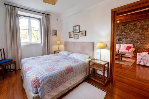 フンシャルにあるOurMadeira - Loja da Lenha, charmingのレンガの壁、ベッド付きのベッドルーム1室