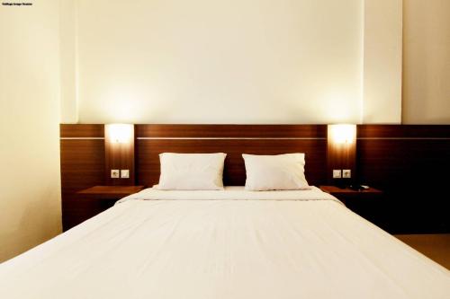Postel nebo postele na pokoji v ubytování Alzara Hotel Syariah