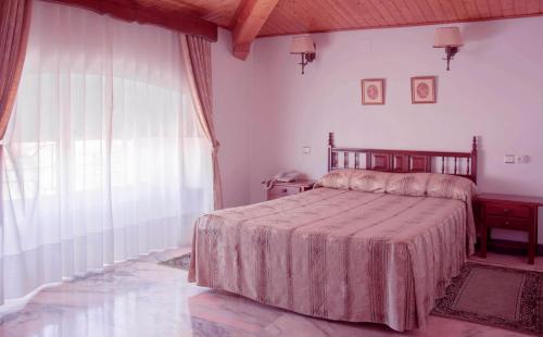 een slaapkamer met een bed en een groot raam bij Victoria in Trujillo