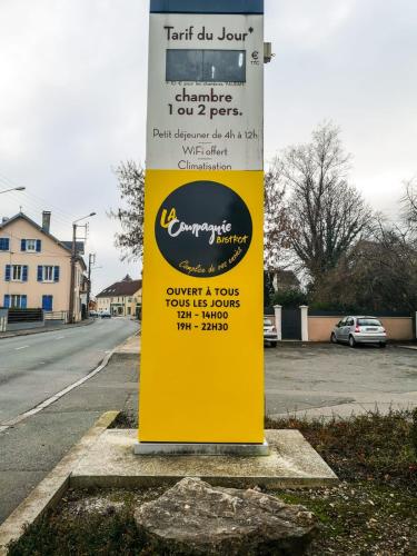 a yellow sign sitting on the side of a street at ibis Belfort Danjoutin in Belfort