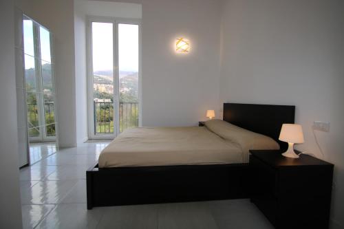 een slaapkamer met een bed en een groot raam bij Villa da Marco in Vico Equense