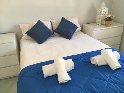 een blauw en wit bed met handdoeken erop bij Avda de las Palmeras Apartment in Benalmádena