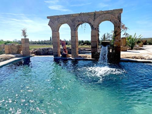 a water fountain in the middle of a pool at Resort Fonte Vulci in Canino