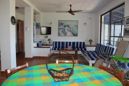 a living room with a table and a couch at Villa La Loma in Ixtapa