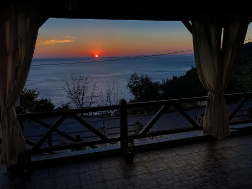 a sunset from a room with a view of the ocean at House of the Rising Sun in Chorefto
