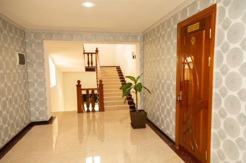 a hallway with a staircase and a potted plant at Cinzano Complex in Samarkand