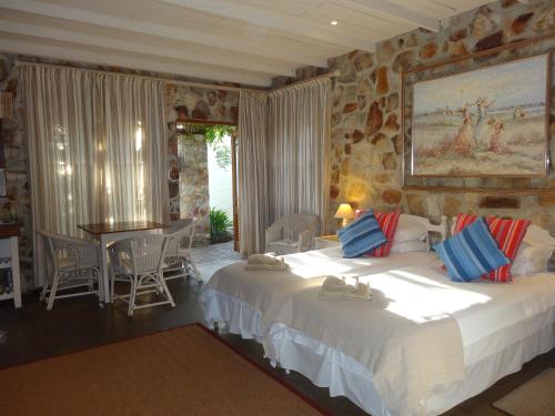 a bedroom with a large bed and a table and chairs at Braeview Guest House in Hermanus