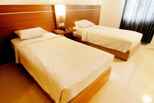 Postel nebo postele na pokoji v ubytování Alzara Hotel Syariah