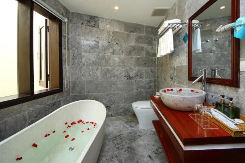 a bathroom with a tub and a sink at Threeway Riverside Villa in Hoi An