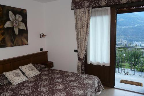 a bedroom with a bed and a window with a view at Affittacamere Verger Plein Soleil in Saint-Pierre