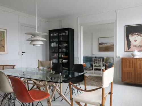 uma sala de jantar com uma mesa de vidro e cadeiras em ApartmentInCopenhagen Apartment 1360 em Copenhague