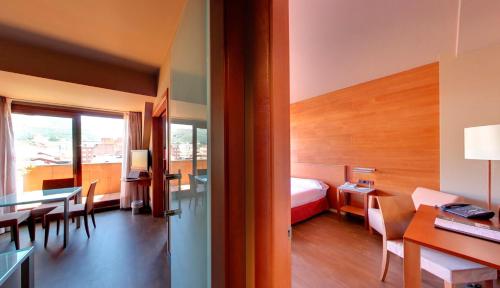 a hotel room with a bed and a table and chairs at Silken Monumental Naranco in Oviedo