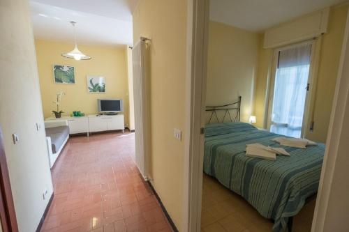 a bedroom with a green bed and a bathroom at Mae's Apartment in Monterosso al Mare