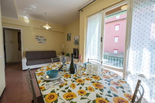 a dining room table with a table cloth with sunflowers on it at Mae's Apartment in Monterosso al Mare