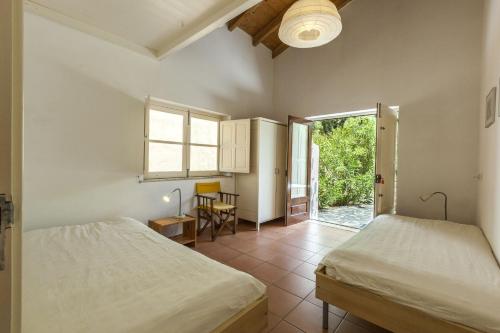 een slaapkamer met 2 bedden en een glazen schuifdeur bij Monte Maravilhas in Odemira