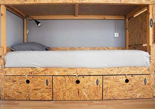 a bed on top of a wooden dresser at Watermark Surf House in Espinho