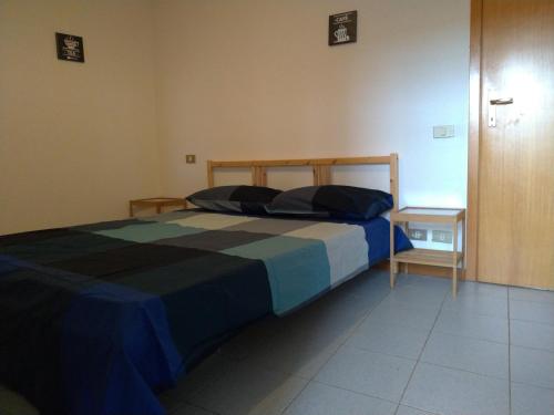 a bedroom with a bed with a blue and black blanket at Via Brecce Bianche, 70 in Ancona